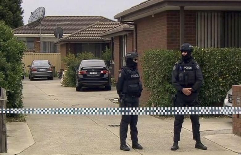 In this image made from video, police stand guard outside a raided property connected to a foiled terror attack, Nov. 20, 2018, in Melbourne, Australia.