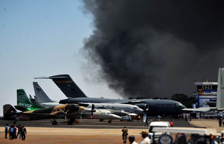 Smoke billows past a row of parked planes after a fire broke out in a parking lot during the Aero India show at the Yelahanka Air Force Station in Bengaluru, India, February 23, 2019. 
