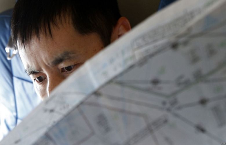 A Japan Coast Guard officer studies a map onboard their Gulfstream V Jet aircraft, customized for search and rescue operations, as they search for the missing Malaysia Airlines MH370 plane over the waters of the South China Sea, March 15, 2014.