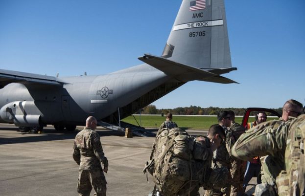 This Oct. 29, 2018 photo provided by the U.S. Air Force shows deployers from Headquarters Company, 89th Military Police Brigade, Task Force Griffin getting ready to board a C-130J Super Hercules from Little Rock, Arkansas, at Fort Knox, Kentucky.