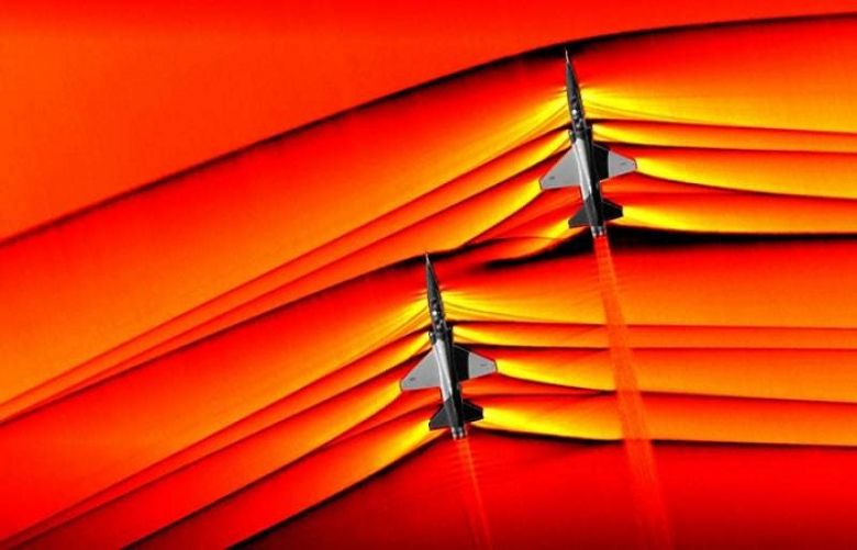This handout colorized composite image released by NASA on March 5, 2019 shows two T-38 aircrafts flying in formation at supersonic speeds producing shockwaves that are typically heard on the ground as a sonic boom.