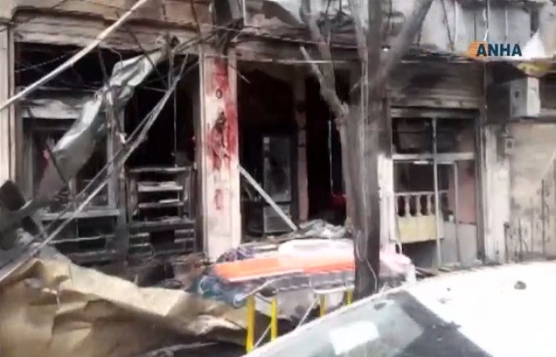 An image grab taken from a video published by Hawar News Agency (ANHA) on January 16, 2019, shows an unidentified member of security forces at the scene of a bomb attack in the northern Syrian city of Manbij.