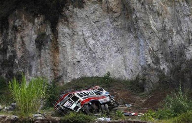 A view shows an autobus at its crash site after going off a cliff.