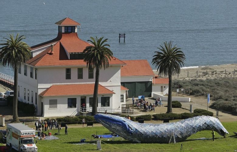 Artist Joel Deal Stockdill, lower right, works on a blue whale art piece made from discarded single-use plastic at Crissy Field in San Francisco, Oct. 12, 2018.