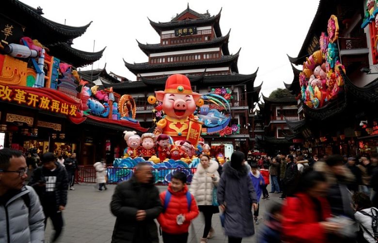 People walk by a giant decoration in the shape of a pig ahead of the upcoming Chinese Lunar New Year in Yu Yuan Garden in Shanghai, China, Jan. 31, 2019.
