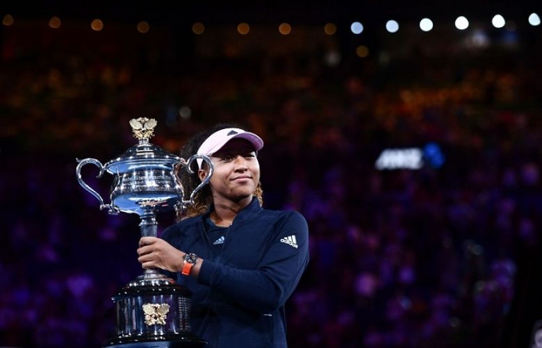 Naomi Osaka poses with the championship trophy during the presentation ceremony after her victory. 